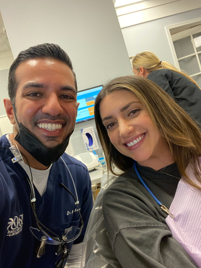 Dr. Arora smiling with a patient after a cosmetic dentistry procedure at Oasis Family Dentistry