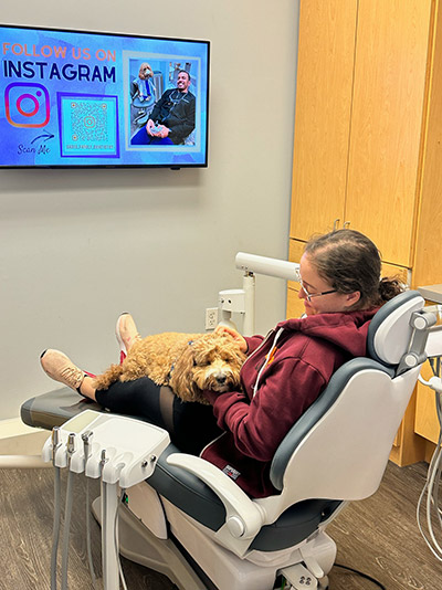 Emotional support office dog sitting with patient during orthodontic treatment